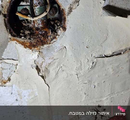 צינור חלוד בקיר עם טיח מתקלף וכלים לתיקון